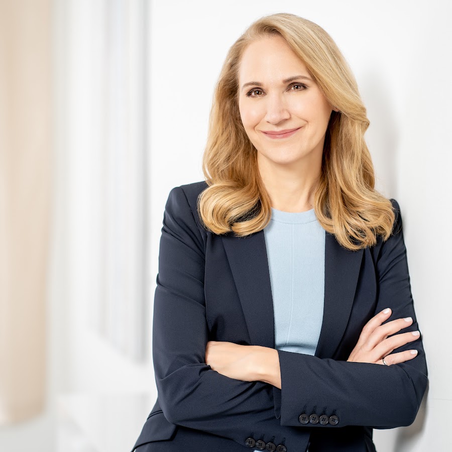 April Dunford smiling in a navy blazer against a light background