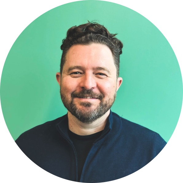 Daniel Priestley smiling against a green background