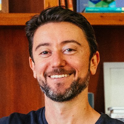 Lenny Rachitsky smiling in front of a wooden bookshelf